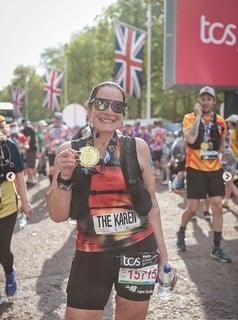 Attorney Karen Vincent holding her medal after completing the Marathon