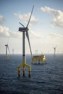 Offshore wind farm turbines at dusk in the middle of the sea