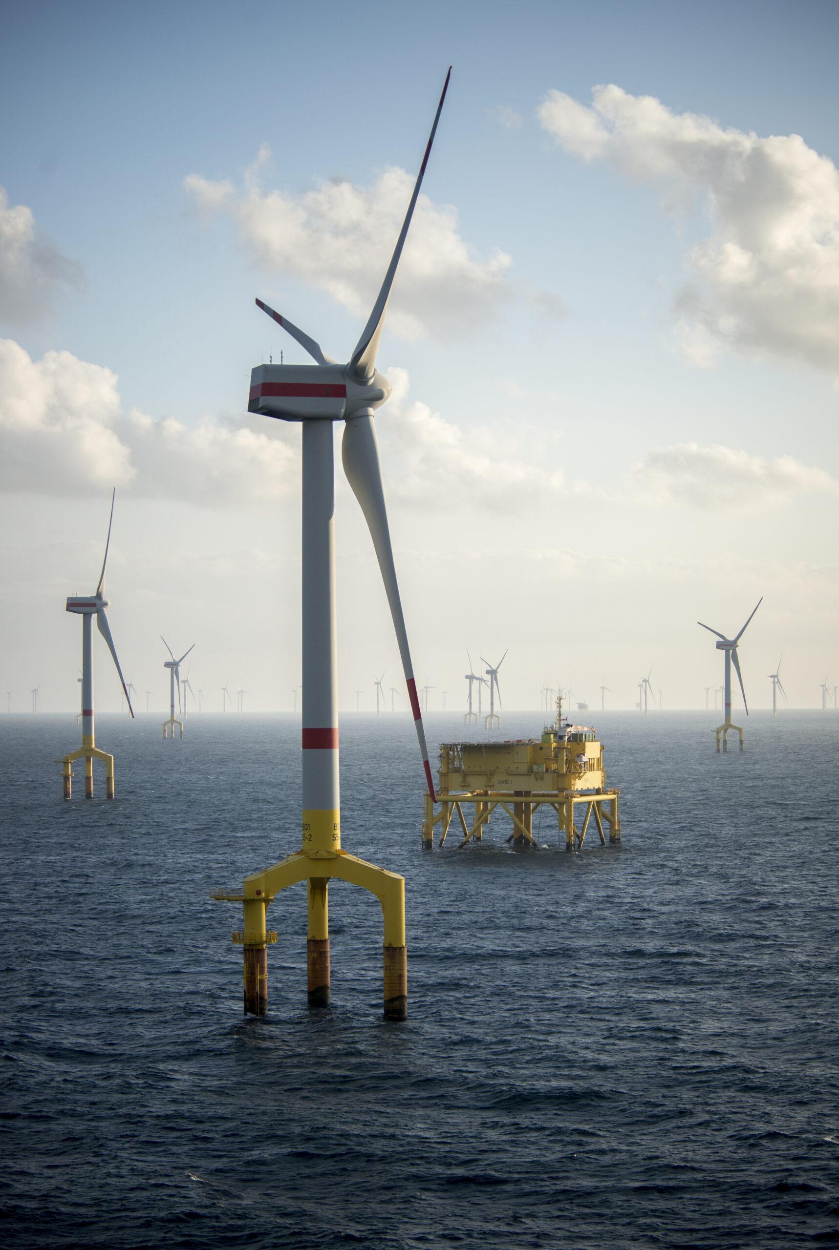 Offshore wind farm turbines at dusk in the middle of the sea